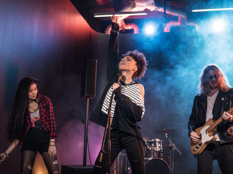 Young multiethnic rock and roll band performing hard rock music on stage